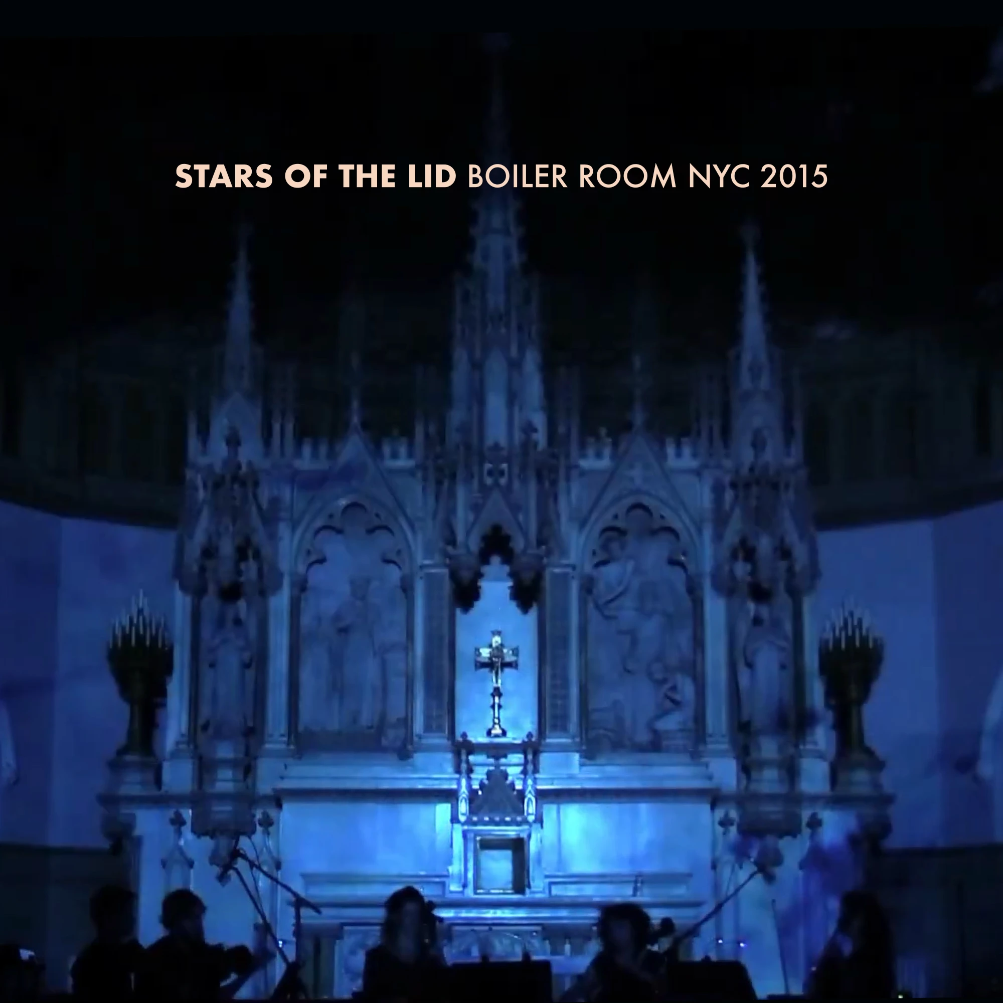 Blue light projections of clouds against the altar of a church, with silhouettes of a string quartet at the bottom